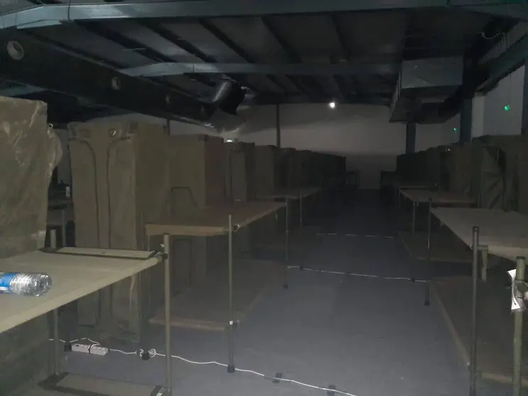 Camas de lona en un oscuro pabellón para los militares desplazados a Asturias